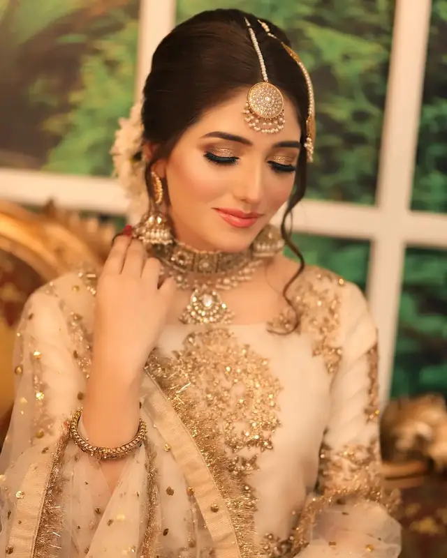 A bride in full hair, make-up and jewellery