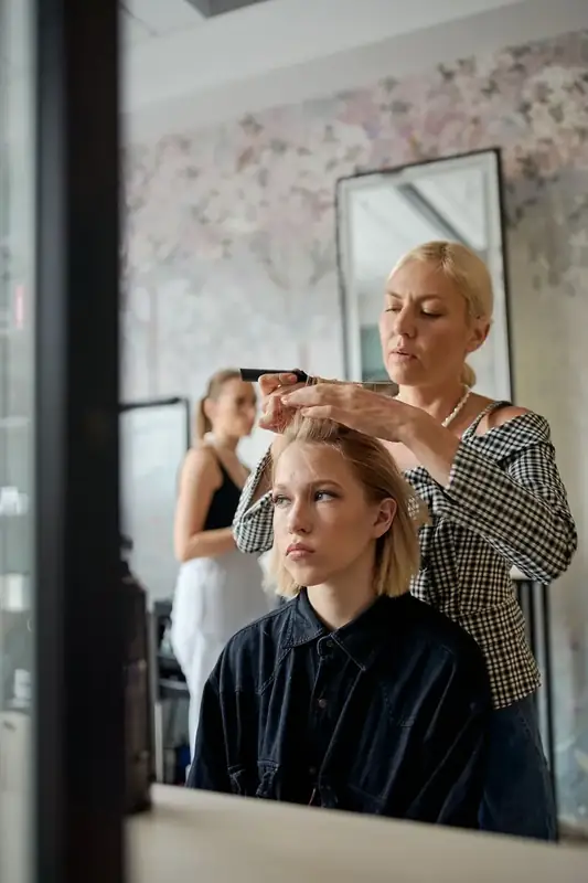 A stylist finishing a client's blow-dry at the mirror